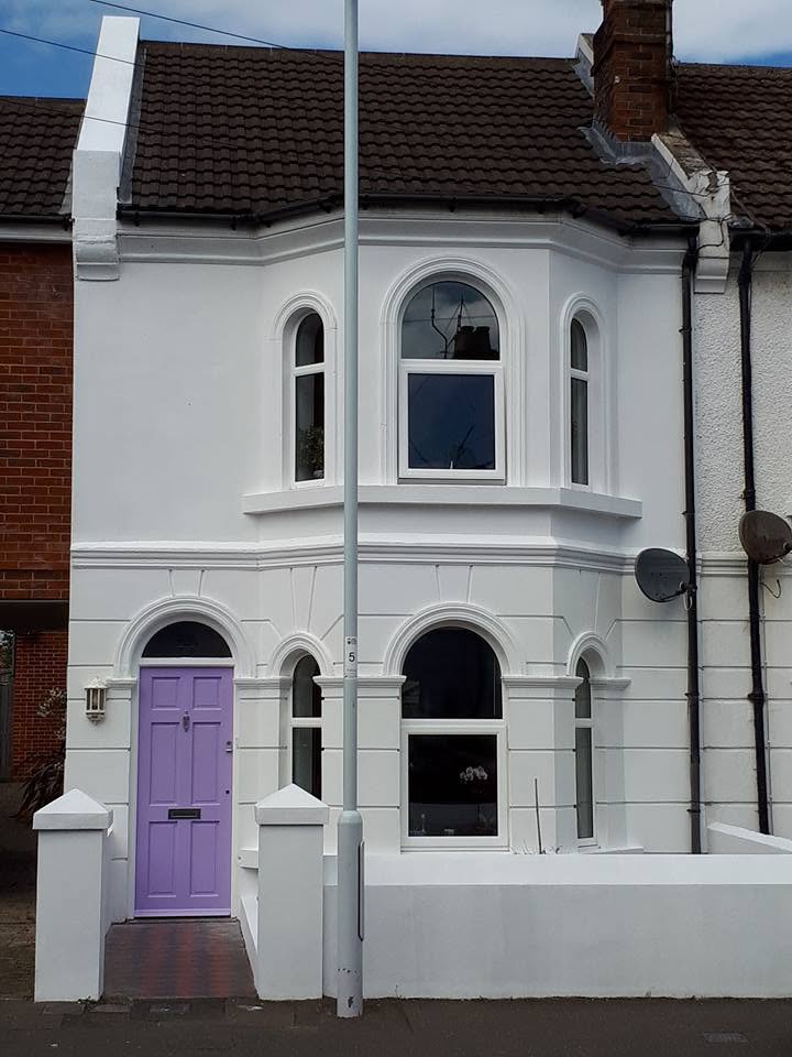 White rendered house with purple door, decorated by R. Reeds